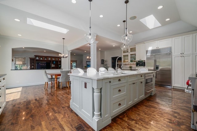 2135 Kenton Ln, Libertyville, IL 60048 - kitchen featuring a skylight, built in appliances, ornamental molding, light countertops, and glass insert cabinets