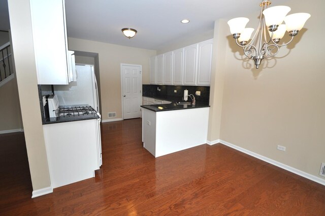 24952 Clare Cir, Manhattan, IL 60442 - kitchen with dark countertops, a chandelier, white cabinetry, dark wood-style flooring, and stove