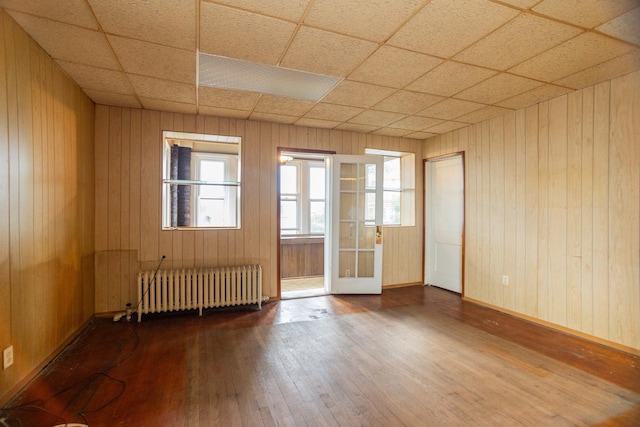5028 N Sawyer Ave, Chicago, IL 60625 - unfurnished room with radiator heating unit, hardwood / wood-style flooring, wood walls, and french doors