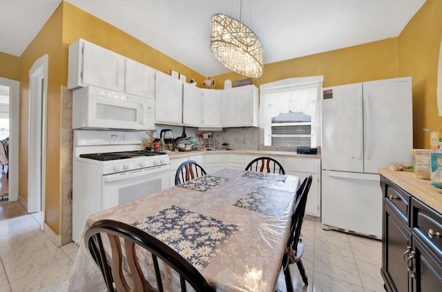 2816 Cuyler Ave, Berwyn, IL 60402 - kitchen with white appliances, light countertops, white cabinetry, pendant lighting, and a chandelier