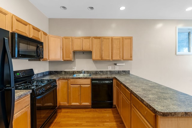 5028 W Lawrence Ave, Chicago, IL 60630 - kitchen with black appliances, light wood-style floors, a peninsula, dark countertops, and recessed lighting