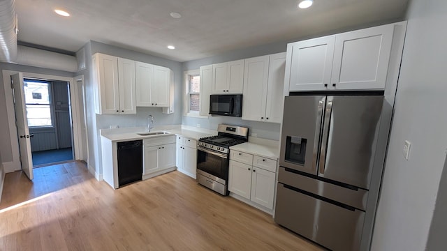 5028 W Lawrence Ave, Chicago, IL 60630 - kitchen with black appliances, white cabinetry, light countertops, recessed lighting, and light wood-style floors