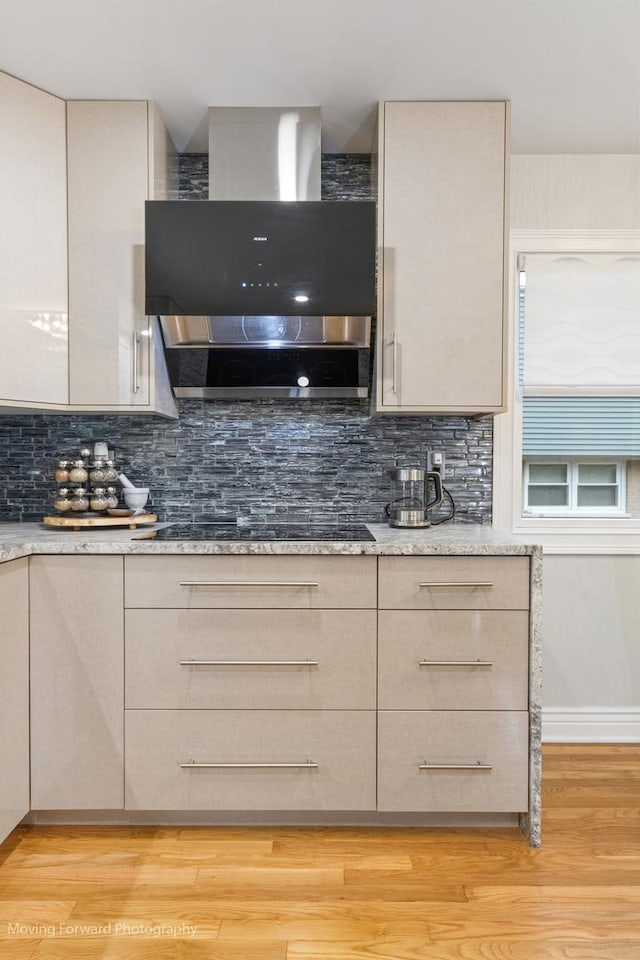 1145 S Chestnut Ave, Arlington Heights, IL 60005 - kitchen featuring wall chimney exhaust hood, black electric cooktop, tasteful backsplash, light stone counters, and light wood-type flooring