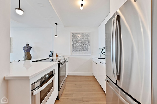 1560 N Sandburg Ter Unit 2810J, Chicago, IL 60610 - kitchen with stainless steel appliances, white cabinets, light wood-style flooring, light countertops, and pendant lighting