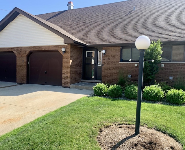 488 Fairview Dr Unit 0, Manhattan, IL 60442 - ranch-style house with brick siding, concrete driveway, an attached garage, a front lawn, and roof with shingles
