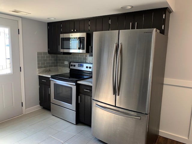 488 Fairview Dr Unit 0, Manhattan, IL 60442 - kitchen with stainless steel appliances, dark cabinets, light countertops, and decorative backsplash