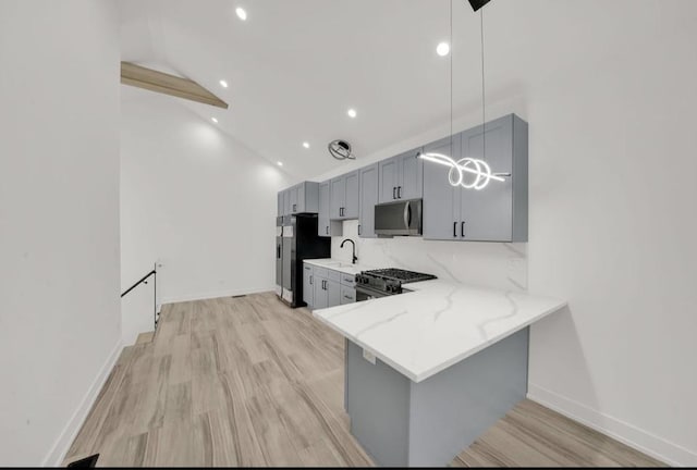 1444 W 49th Pl, Chicago, IL 60609 - kitchen with gray cabinetry, range with gas cooktop, stainless steel fridge, light stone countertops, and light wood-type flooring