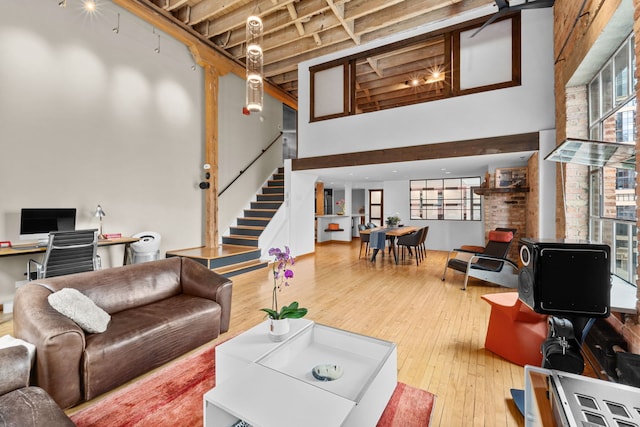 531 S Plymouth Ct Unit 602, Chicago, IL 60605 - living area featuring stairs, a towering ceiling, healthy amount of natural light, a desk, and wood-type flooring