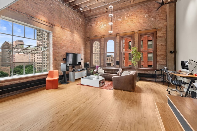 531 S Plymouth Ct Unit 602, Chicago, IL 60605 - living area featuring a high ceiling, brick wall, healthy amount of natural light, hardwood / wood-style flooring, and an office area