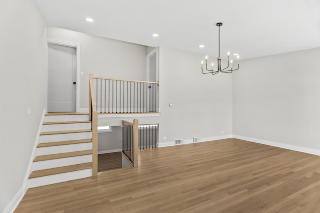 319 Kilpatrick Ave, Wilmette, IL 60091 - unfurnished room featuring a chandelier, wood finished floors, recessed lighting, and stairs