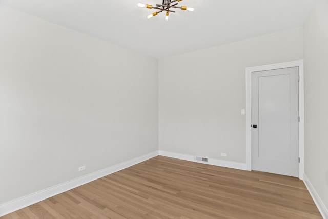319 Kilpatrick Ave, Wilmette, IL 60091 - unfurnished room featuring a chandelier and light wood-type flooring