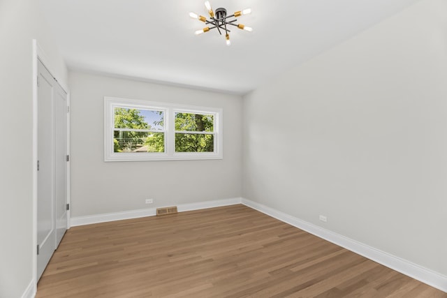 319 Kilpatrick Ave, Wilmette, IL 60091 - unfurnished bedroom with a chandelier, light wood-style flooring, and a closet