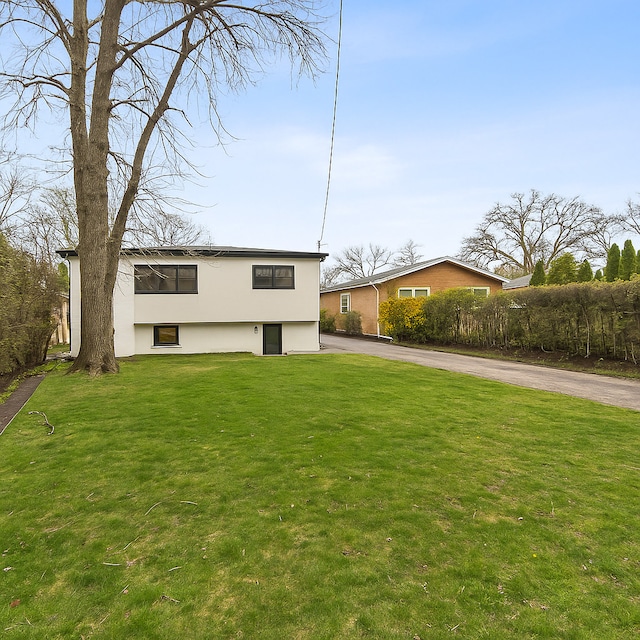 319 Kilpatrick Ave, Wilmette, IL 60091 - view of front facade with driveway, a front yard, and stucco siding