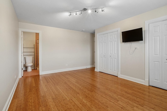 11114 Heritage Dr Unit 3C, Palos Hills, IL 60465 - unfurnished bedroom featuring multiple closets, light wood finished floors, and connected bathroom