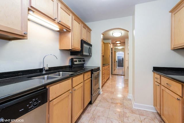 535 N Michigan Ave Unit 2203-2204, Chicago, IL 60611 - kitchen featuring appliances with stainless steel finishes, arched walkways, light brown cabinetry, and dark stone countertops