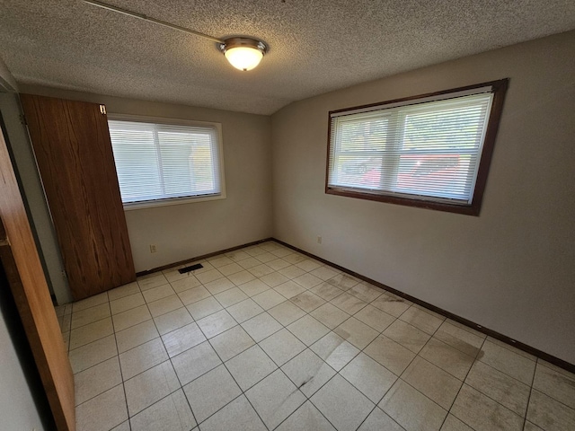 2875 N Vine St, Decatur, IL 62526 - unfurnished room with plenty of natural light, a textured ceiling, and light tile patterned floors
