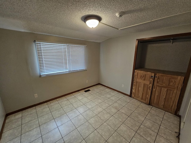 2875 N Vine St, Decatur, IL 62526 - unfurnished bedroom with a textured ceiling and light tile patterned floors