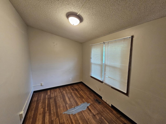 2875 N Vine St, Decatur, IL 62526 - empty room featuring a textured ceiling and dark wood-style flooring