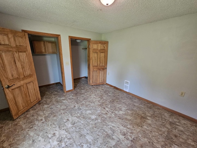 2875 N Vine St, Decatur, IL 62526 - unfurnished bedroom with a textured ceiling and baseboards