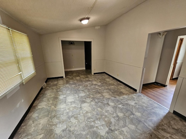 2875 N Vine St, Decatur, IL 62526 - spare room with vaulted ceiling, a textured ceiling, and stone finish flooring