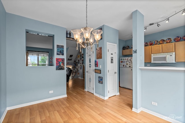 2426 Courtyard Cir Unit 3, Aurora, IL 60506 - unfurnished dining area featuring a chandelier and light wood-style flooring