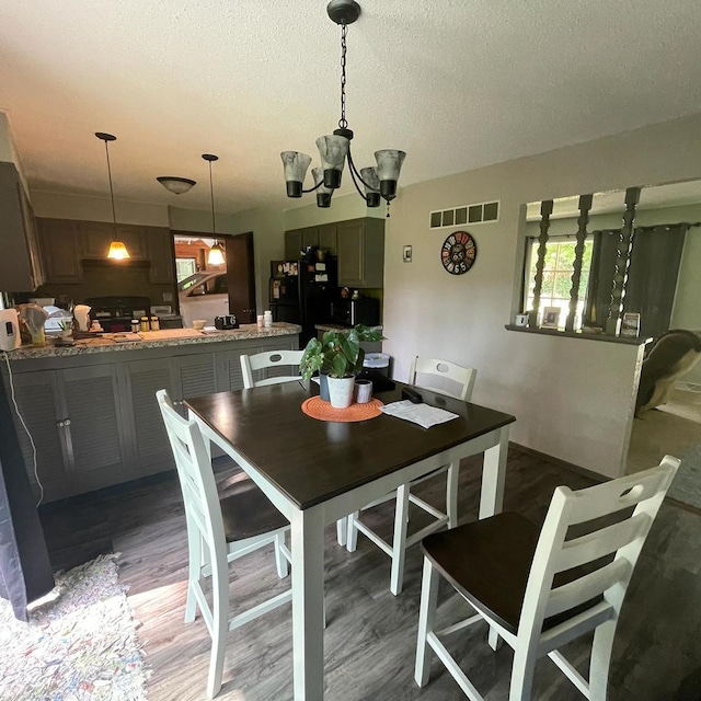 112 Crestview Dr, Hamilton, IL 62341 - dining area featuring a textured ceiling, wood finished floors, and a chandelier