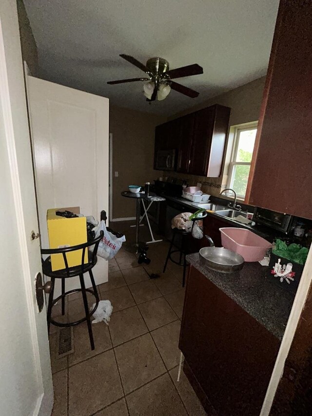 8427 S Peoria St, Chicago, IL 60620 - kitchen with dark countertops, dark tile patterned flooring, and a ceiling fan