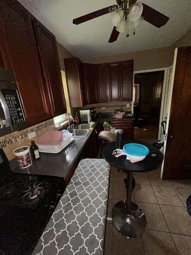 8427 S Peoria St, Chicago, IL 60620 - kitchen with a ceiling fan, stainless steel microwave, backsplash, tile patterned flooring, and dark brown cabinetry