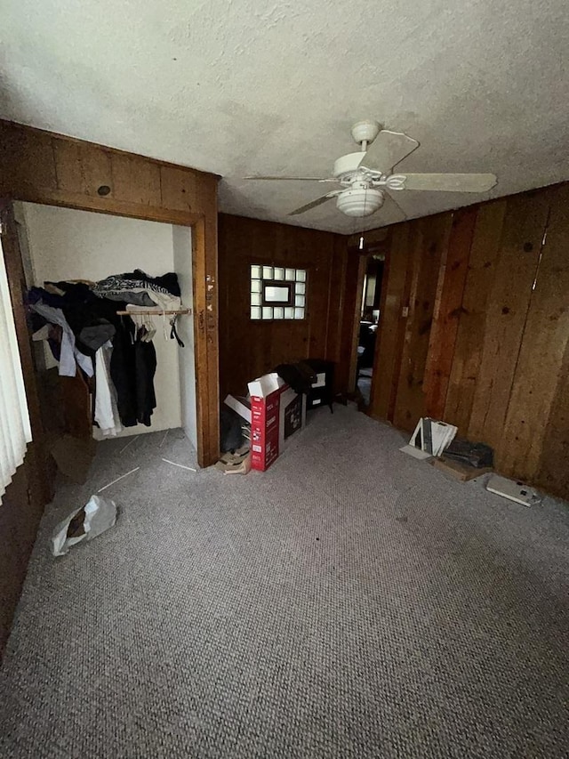 8427 S Peoria St, Chicago, IL 60620 - unfurnished living room featuring wood walls, carpet flooring, a textured ceiling, and ceiling fan