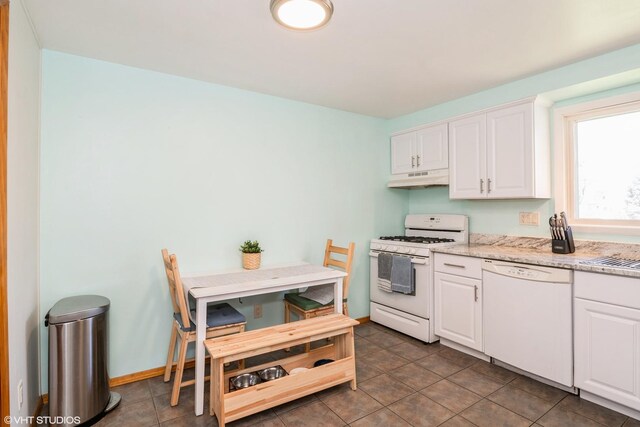 31 Medinah Ave, Fox Lake, IL 60020 - kitchen with white appliances, under cabinet range hood, white cabinets, light stone counters, and tile patterned flooring