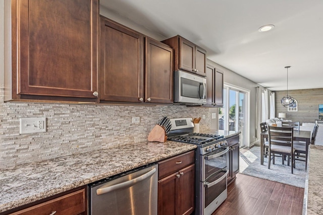 707 Brighton Dr, Pingree Grove, IL 60140 - kitchen with appliances with stainless steel finishes, dark wood-style flooring, light stone countertops, tasteful backsplash, and decorative light fixtures