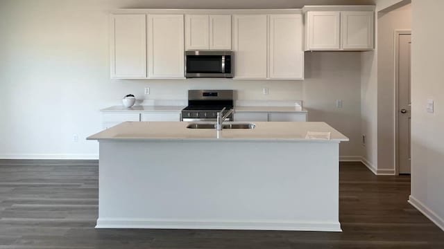 5025 Yates Dr, Mount Pleasant, WI 53403 - kitchen featuring appliances with stainless steel finishes, dark wood-style flooring, an island with sink, and white cabinets