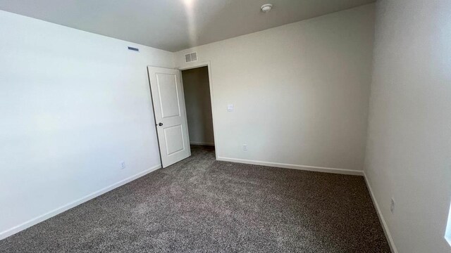 5025 Yates Dr, Mount Pleasant, WI 53403 - spare room featuring dark carpet and a smoke detector