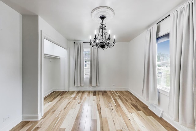 915 Carol Ave, Elgin, IL 60123 - unfurnished dining area with a chandelier and light wood finished floors