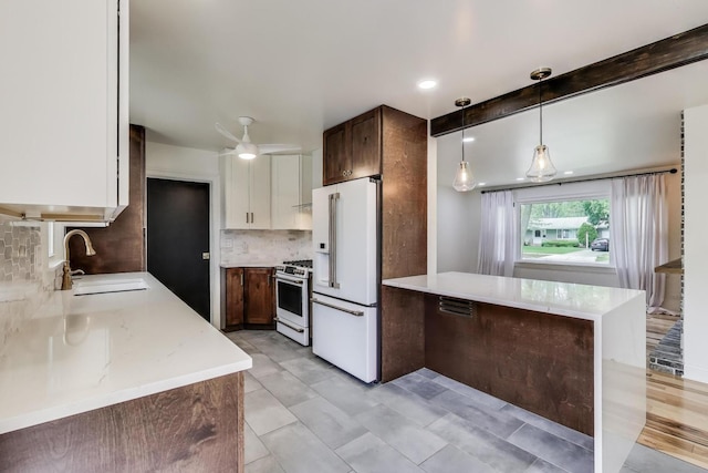 915 Carol Ave, Elgin, IL 60123 - kitchen featuring white appliances, a peninsula, backsplash, hanging light fixtures, and light stone countertops