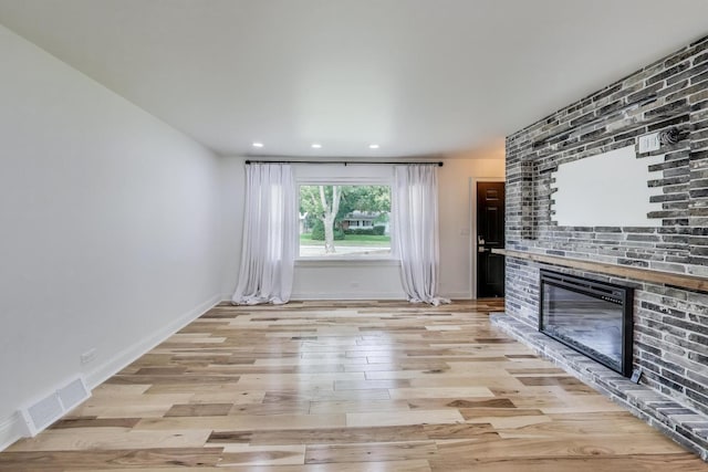 915 Carol Ave, Elgin, IL 60123 - unfurnished living room featuring light wood-type flooring, a brick fireplace, and recessed lighting