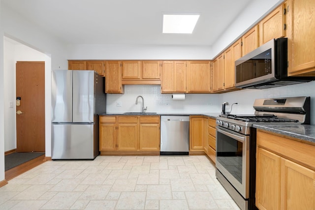 5360 N Lowell Ave Unit 502, Chicago, IL 60630 - kitchen featuring appliances with stainless steel finishes, stone tile flooring, dark countertops, and backsplash