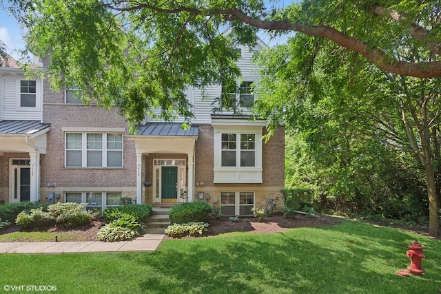 5530 Cambridge Way, Hanover Park, IL 60133 - view of front of property with a standing seam roof, a front lawn, a metal roof, and brick siding