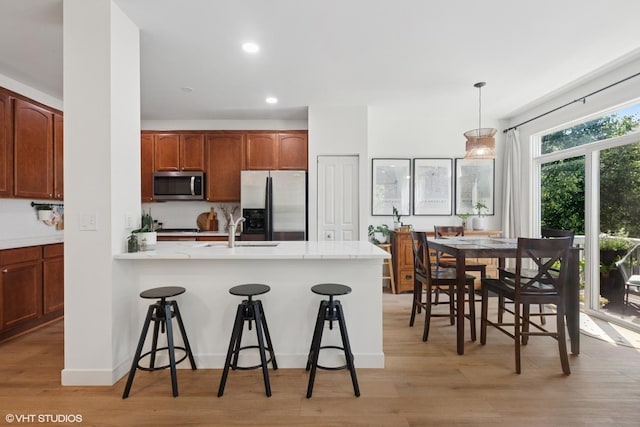 5530 Cambridge Way, Hanover Park, IL 60133 - kitchen featuring appliances with stainless steel finishes, a kitchen bar, light wood-style flooring, a peninsula, and recessed lighting