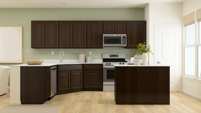 2109 Neubauer Cir, Lindenhurst, IL 60046 - kitchen featuring appliances with stainless steel finishes, light countertops, light wood-type flooring, and dark brown cabinetry