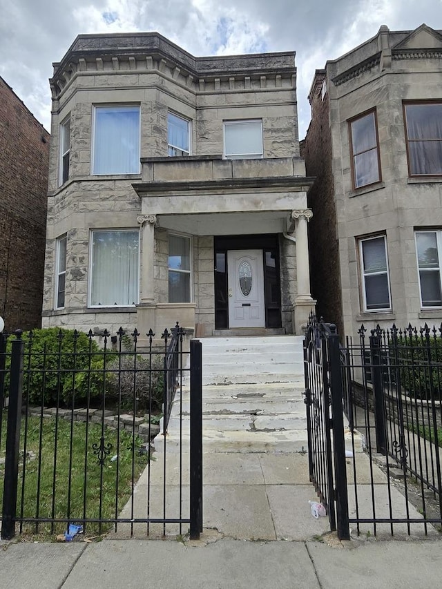 6522 S Peoria St, Chicago, IL 60621 - view of front facade featuring stone siding, a fenced front yard, and a gate