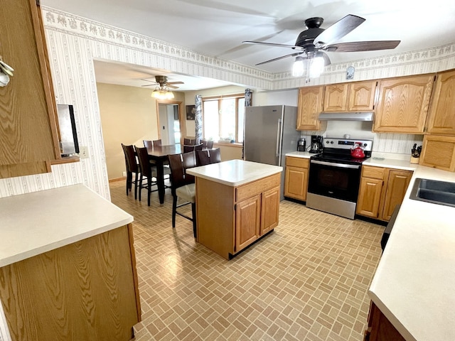 825 Swift Ave, Oglesby, IL 61348 - kitchen featuring appliances with stainless steel finishes, brick patterned floors, under cabinet range hood, wallpapered walls, and light countertops