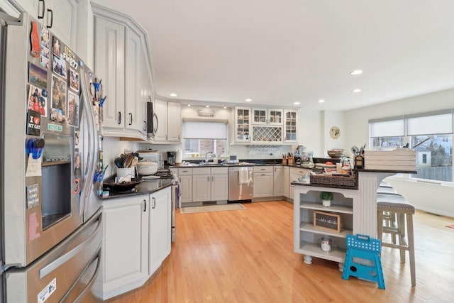 644 N Franklin Ave, Palatine, IL 60067 - kitchen with stainless steel appliances, dark countertops, a peninsula, glass insert cabinets, and light wood-style floors