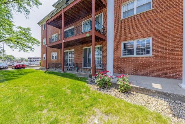 6135 W 94th St Unit A1, Oak Lawn, IL 60453 - back of house with a lawn, brick siding, and a balcony