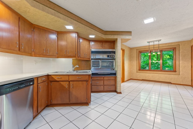 4303 Singleton Close, Rockford, IL 61114 - kitchen with stainless steel appliances, a textured ceiling, light countertops, brown cabinetry, and tasteful backsplash