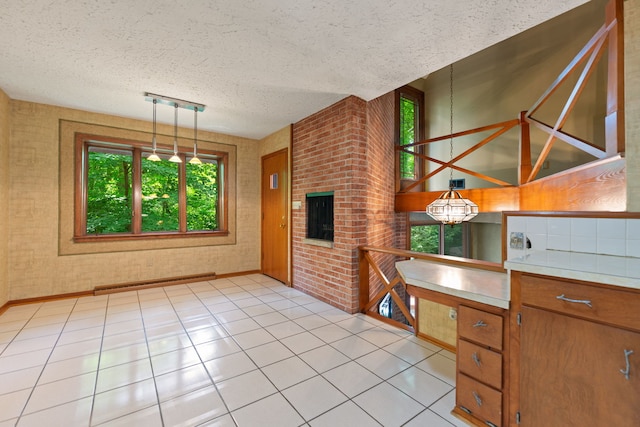 4303 Singleton Close, Rockford, IL 61114 - kitchen featuring healthy amount of natural light, light tile patterned flooring, a textured ceiling, pendant lighting, and light countertops
