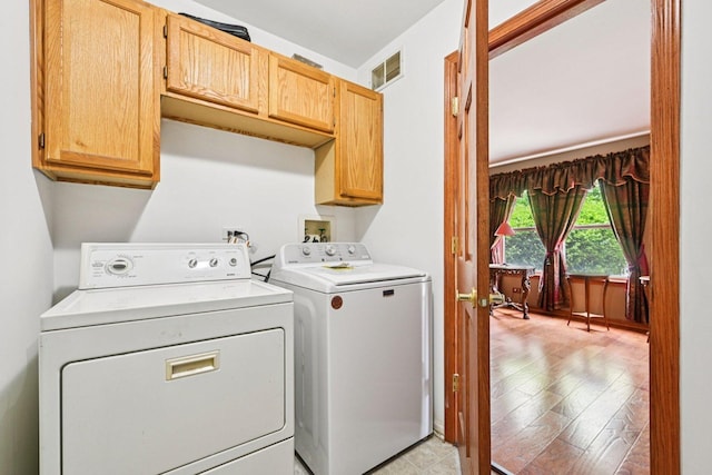 561 Ryegrass Trl, Aurora, IL 60504 - laundry room featuring separate washer and dryer, cabinet space, and light wood-type flooring