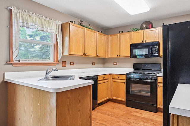 561 Ryegrass Trl, Aurora, IL 60504 - kitchen featuring black appliances, light wood-style floors, light countertops, and a peninsula