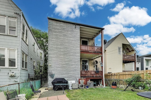 4444 N Spaulding Ave, Chicago, IL 60625 - rear view of house with a fenced backyard, brick siding, and a patio area