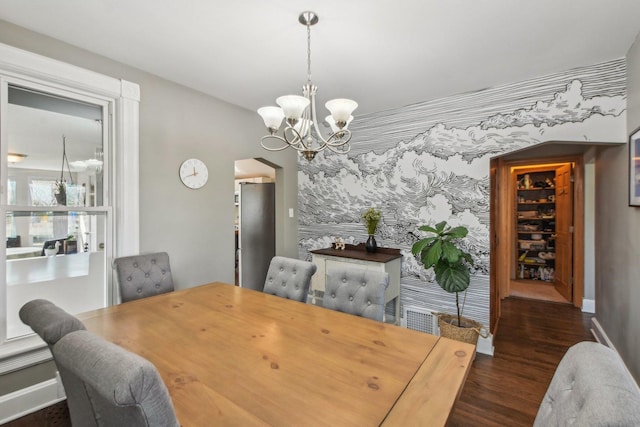 325 2nd St, Downers Grove, IL 60515 - dining space featuring dark wood finished floors, a chandelier, arched walkways, and an accent wall